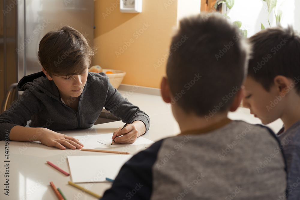 Three friends drawing with colored pencils in the kitchen Three friends drawing with colored pencils in the kitchen