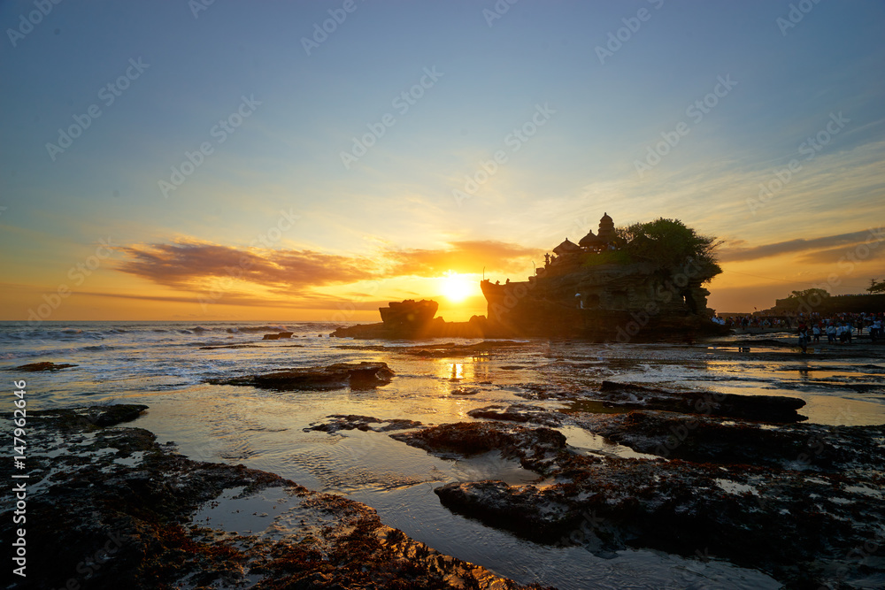 Beautiful balinese landscape. Ancient hinduism temple Tanah lot on the rock against sunset sky. Bali Island, Indonesia.