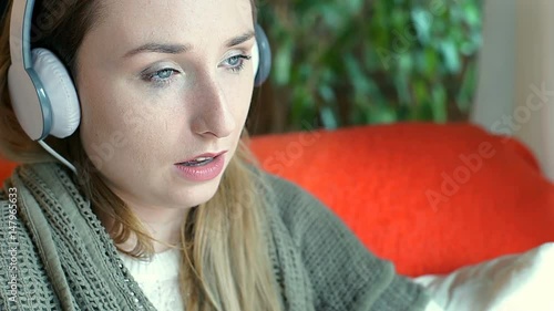Sad girl crying while listening music on headphones and drinking wine
