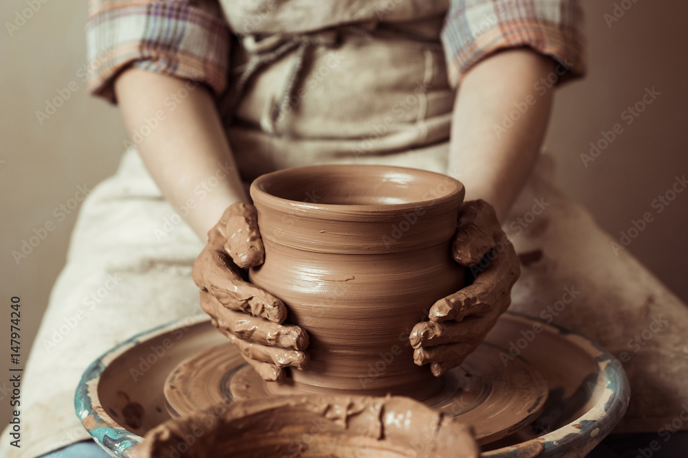 Close up of child hands working on pottery wheel at workshop Close up of child hands working on pottery wheel at workshop