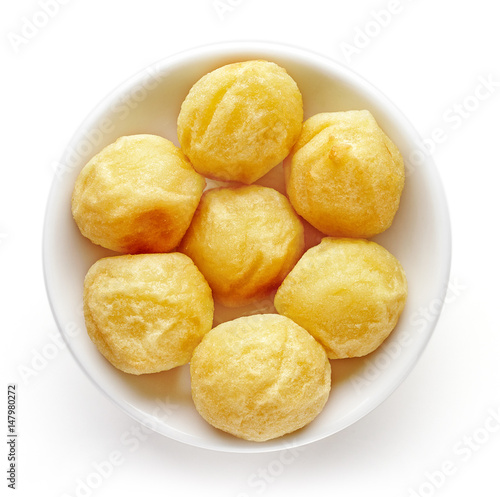Bowl of potato balls isolated on white, from above
