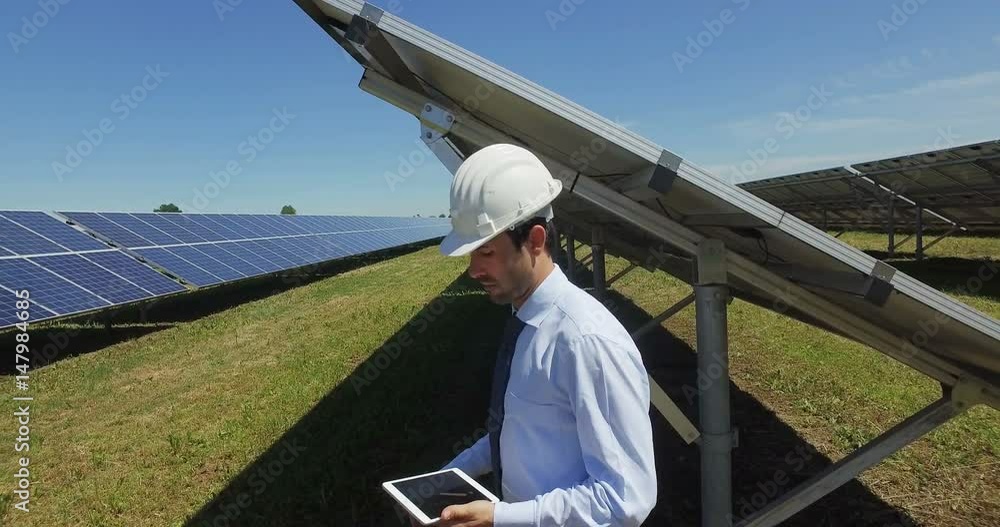 Engineer expert in solar energy photovoltaic panels with remote control performs routine actions for system monitoring using clean, renewable energy. concept applied to the remote support technology. Engineer expert in solar energy photovoltaic panels with remote control performs routine actions for system monitoring using clean, renewable energy. concept applied to the remote support technology.