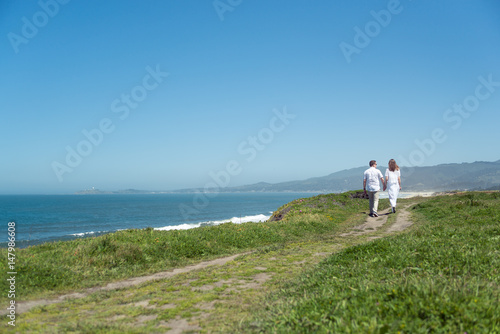 Young romantic couple walking on the trail holding hands