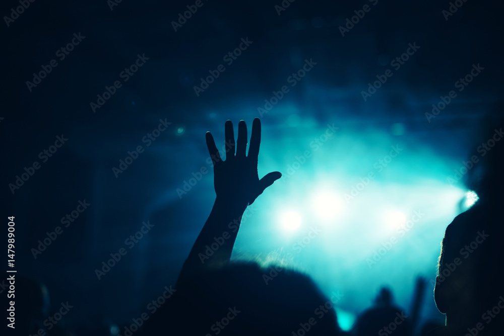 Female hand raised in the air on rock music concert Female hand raised in the air on rock music concert