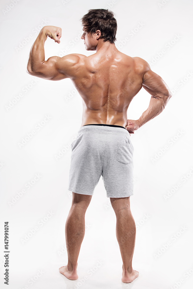 Strong Athletic Man Fitness Model posing back muscles, triceps, latissimus Strong Athletic Man Fitness Model posing back muscles, triceps, latissimus
