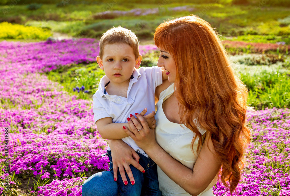 Young mother playing with her little son in the garden. Mother's Day concept Young mother playing with her little son in the garden. Mother's Day concept