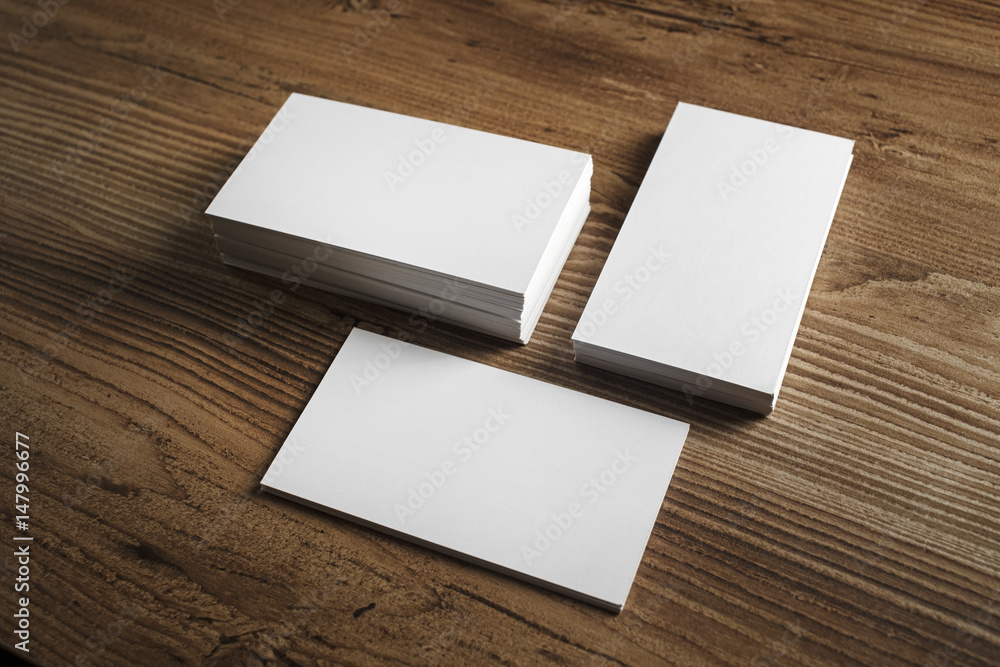 Photo of blank business cards. Blank business cards on wooden table background. Template for ID. Mockup for branding identity. Photo of blank business cards. Blank business cards on wooden table background. Template for ID. Mockup for branding identity.