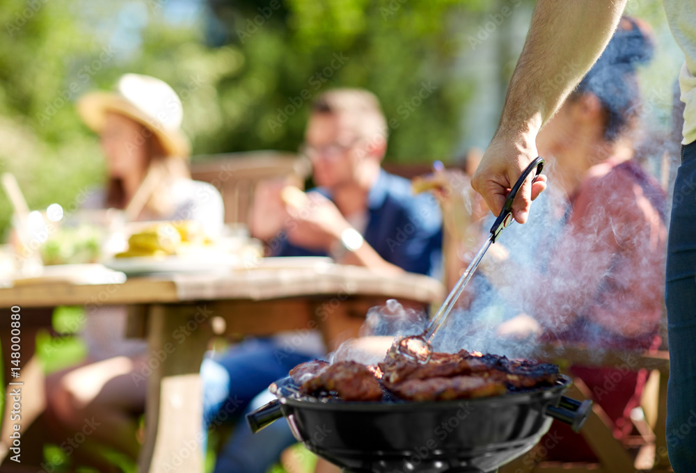 Fototapeta premium man cooking meat on barbecue grill at summer party