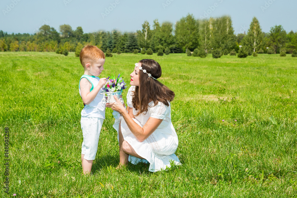 Fototapeta premium Happy family. Young mother and kid boy on sunny day. Portrait mom and son on nature. Positive human emotions, feelings, joy.