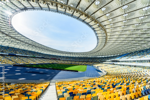 rows of yellow and blue stadium seats on soccer field stadium photo