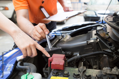 Male mechanic checking car battery