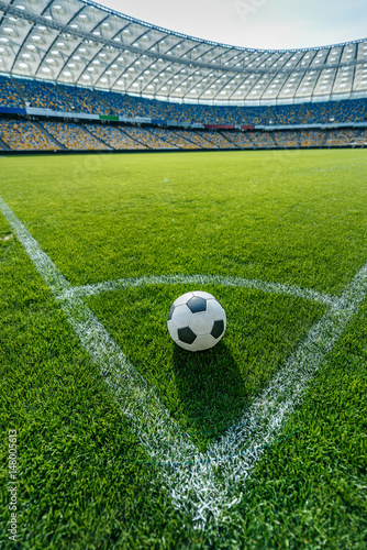soccer ball on grass in corner kick position on soccer field stadium photo