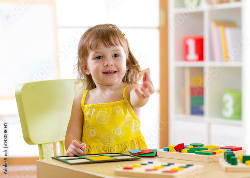 kindergarten child plays in...