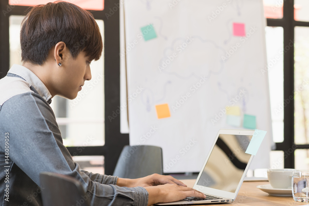 Charming casual man working with laptop in modern office. Charming casual man working with laptop in modern office.