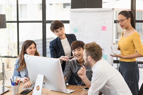 Multiethnic asian group of happy business people working together  meeting and brainstorming in office. Use computer  laptop  tablet  mobile phone.