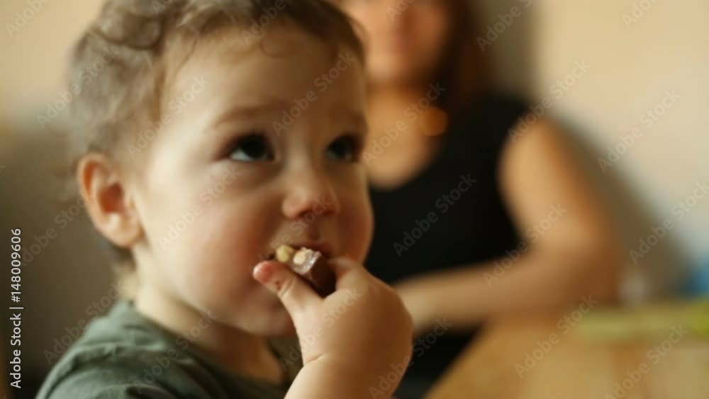 Absorbed baby boy eating tasty chocolate
Absorbed baby boy eating tasty chocolate