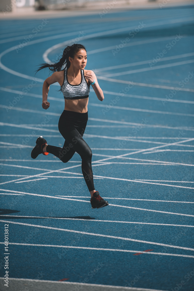 Samolepka Athletic young sportswoman sprinting on running track stadium