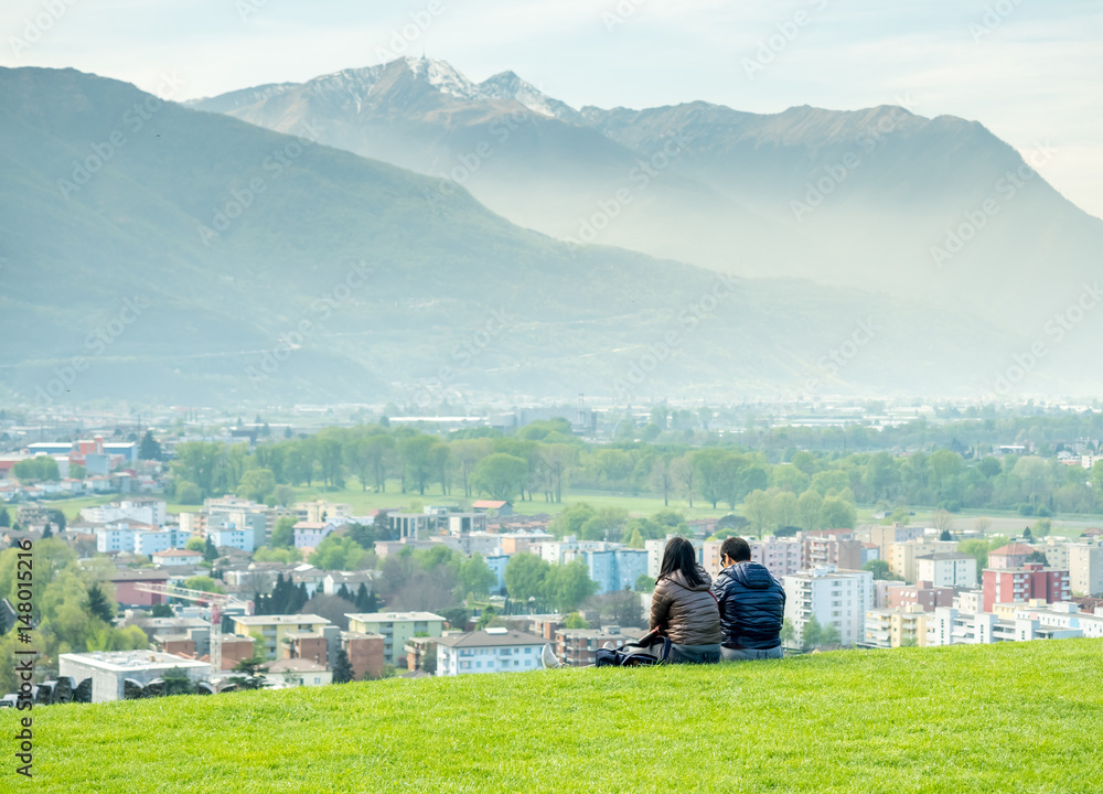 Naklejka premium Two people sit on green grass