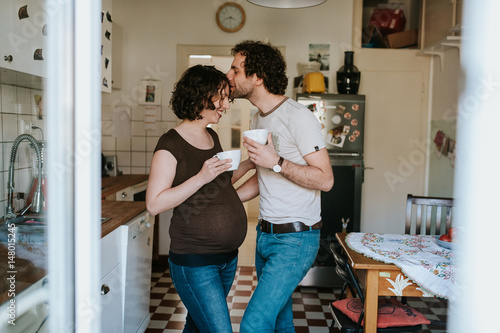 pregnant couple drinking tea in the kitchen photo