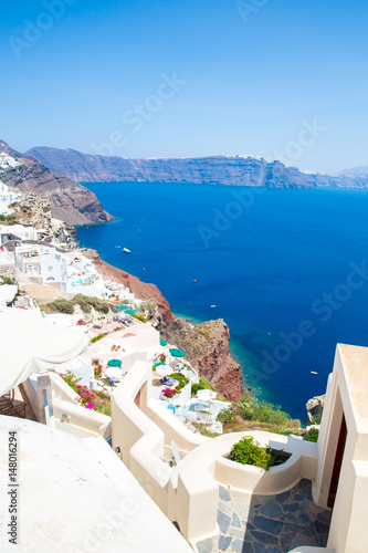 View of Fira town - Santorini island,Crete,Greece. White concrete staircases leading down to beautiful bay with clear blue sky and sea