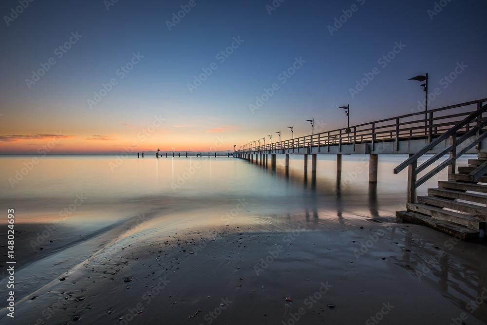 Obraz premium Wooden pier in Mechelinki. Small fishing village in Poland. Amazing Sunrise at the beach