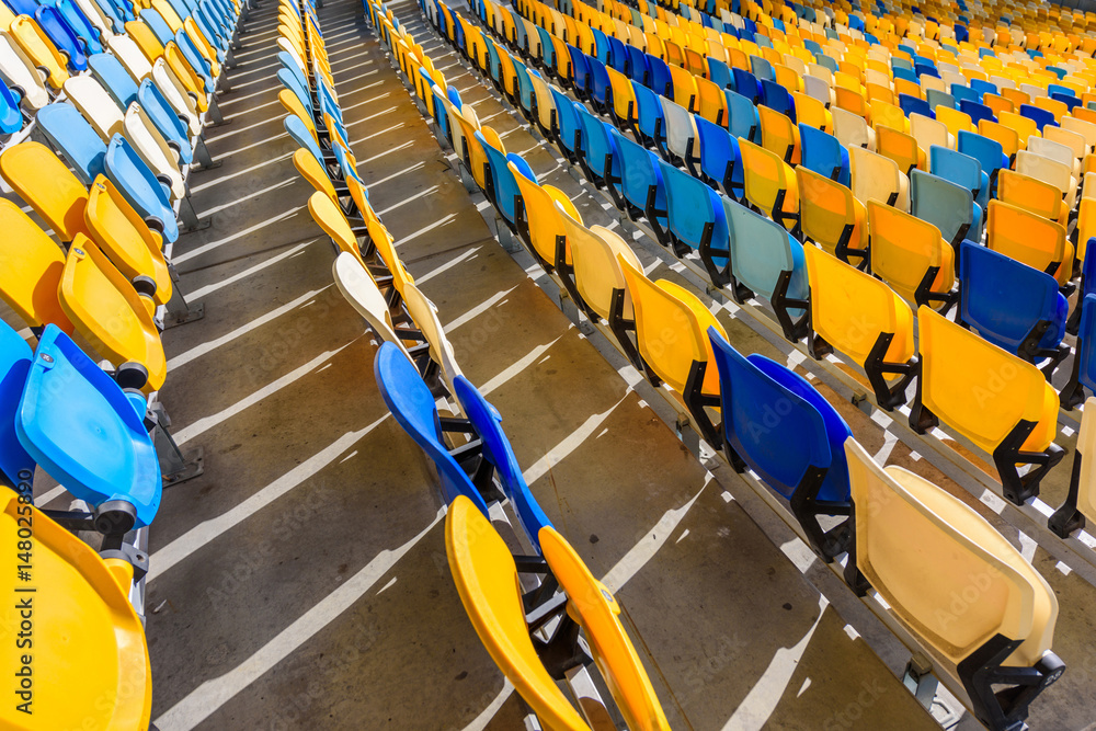 Fototapeta premium rows of yellow and blue stadium seats on soccer stadium