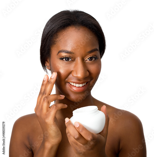 young african american woman applying cream to her face photo