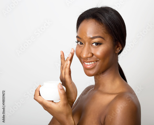 african american beauty using face cream photo