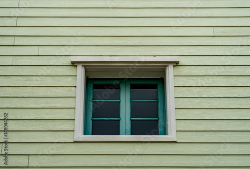 Green windows on old wooden wall
