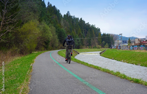 Cyclist, cycle path and river flowing next to it
