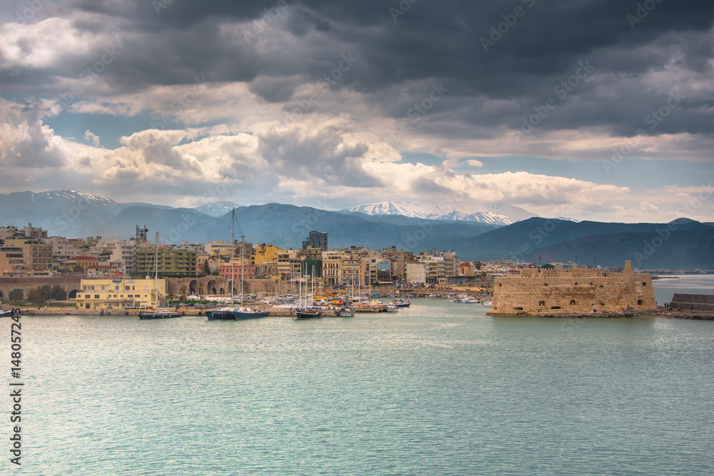 Neoria, old venetian walls of the shipyards at Heraklion with the port and the castle of koule, Crete, Greece.