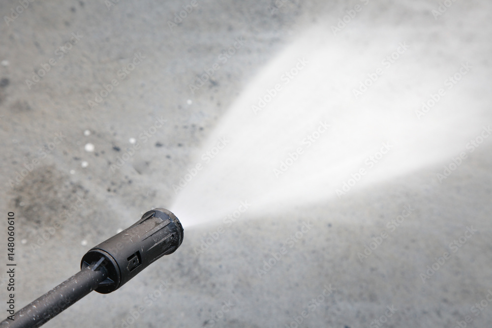 Water hose spray gun washing his cement floor