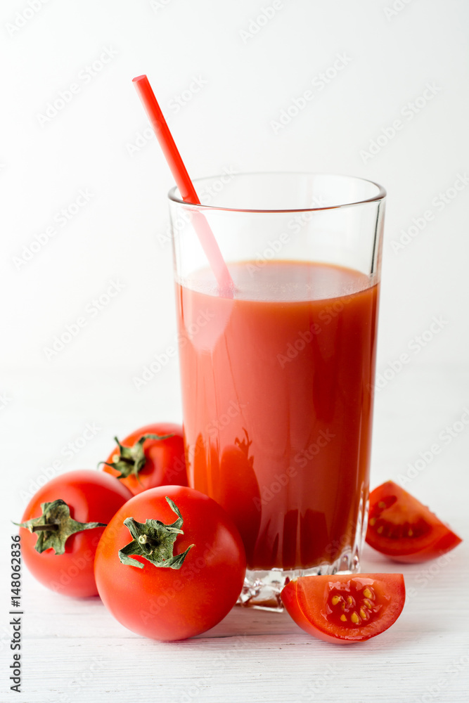 Tomato juice in glass and fresh tomatoes on white wooden table. Tomato juice in glass and fresh tomatoes on white wooden table.