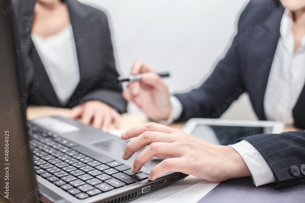 Business woman Hold the pen and pointing screen teaching and discussing Project at Computer notebook and laptop,tablet at Modern Office Environment on Table desk . business Team strategy as concept. Business woman Hold the pen and pointing screen teaching and discussing Project at Computer notebook and laptop,tablet at Modern Office Environment on Table desk . business Team strategy as concept.