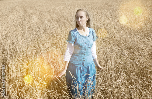 The beautiful woman in a blue long dress in the field of ripe cereals.. © Konstantin Kulikov
