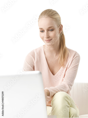 Shot of a beautiful young woman using her laptop while sitting at isolated white background with copy space. 