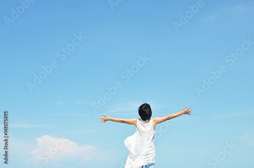 Asian woman feels happy with blue sky background 