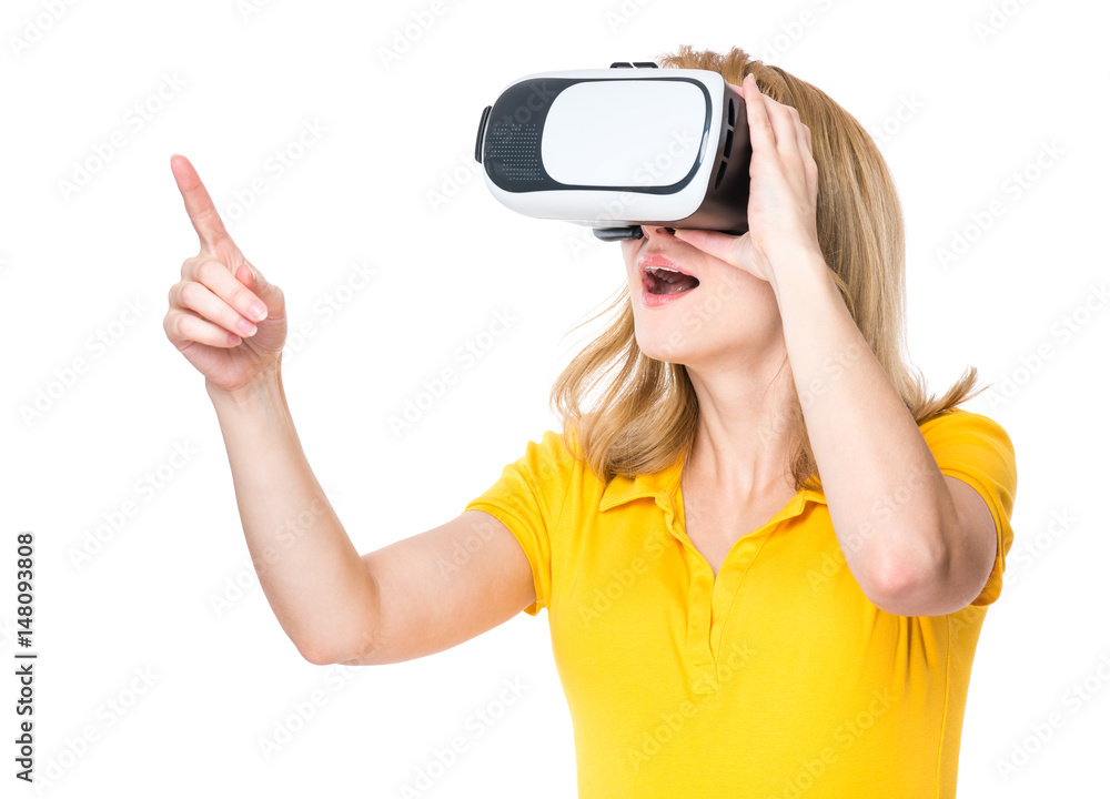 Woman wearing virtual reality goggles watching movies or playing video games, isolated on white background. Cheerful surprised girl looking in VR glasses, pointing with finger. Woman wearing virtual reality goggles watching movies or playing video games, isolated on white background. Cheerful surprised girl looking in VR glasses, pointing with finger.