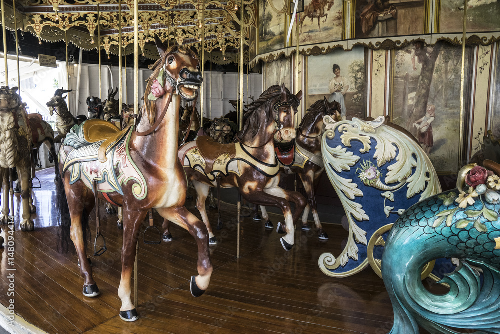 Vintage restored carousel hand carved wooden horses on a merry go round ride