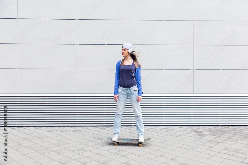 Young girl driving skateboard in urban environment. Young girl driving skateboard in urban environment.
