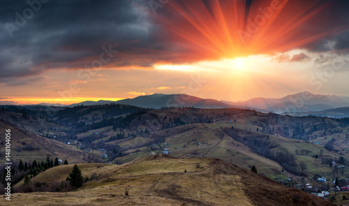 Panoramic landscape in the mountains at sunrise. Dramatic sky with colorful clouds. 