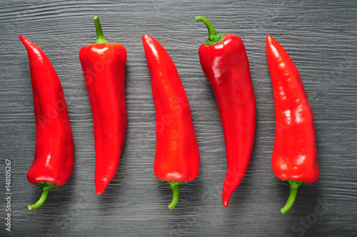 Sweet red Kapia peppers on a dark shale stone background photo