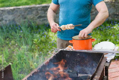 Man stringing meat on a skewer. Shashlik - cooking barbecue. Stringing meat on ramrod. photo