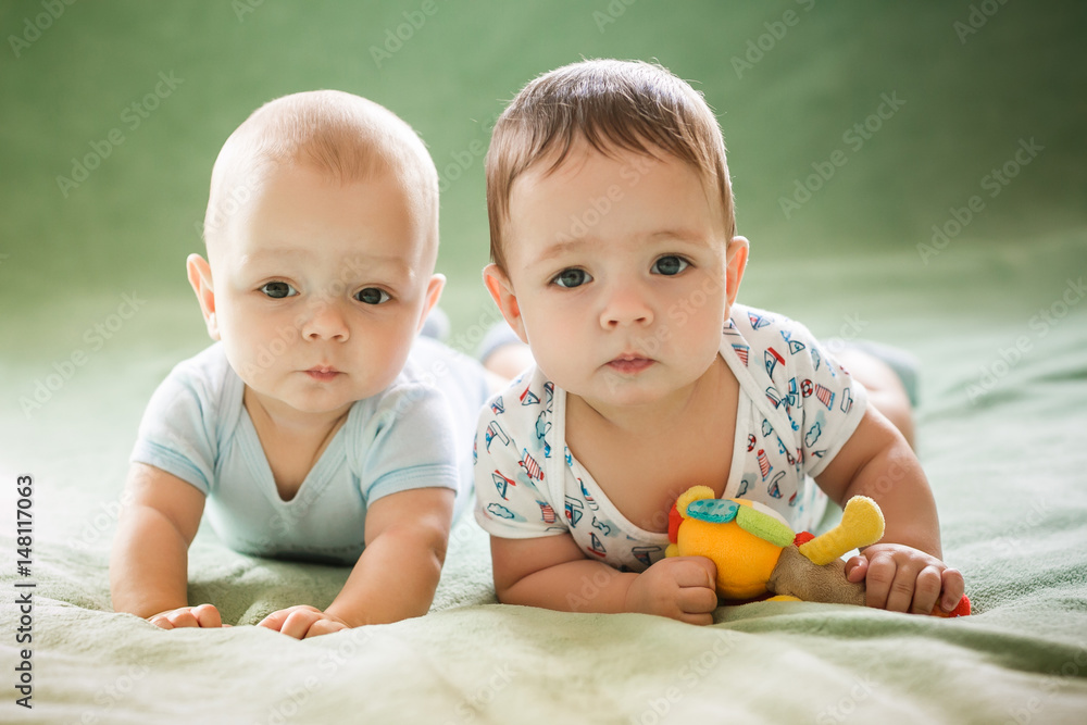 The newborn babies brother boy is lying on the blanket in the bed The newborn babies brother boy is lying on the blanket in the bed