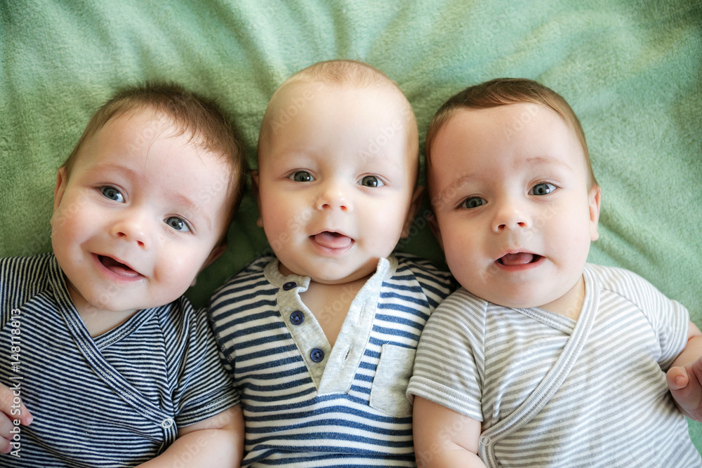 Portrait of newborn triplets are lying in the bed Portrait of newborn triplets are lying in the bed