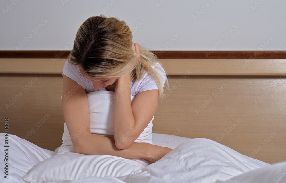 Sleep Disorders, insomnia. Woman Suffering From Depression Sitting On Bed In Pajamas Sleep Disorders, insomnia. Woman Suffering From Depression Sitting On Bed In Pajamas