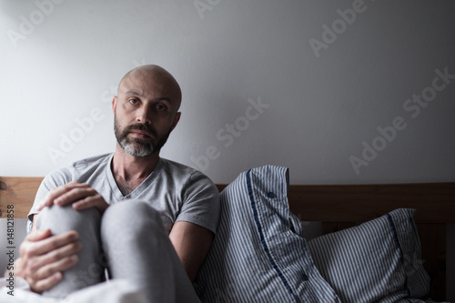 Mid forties depressed man in bed at home