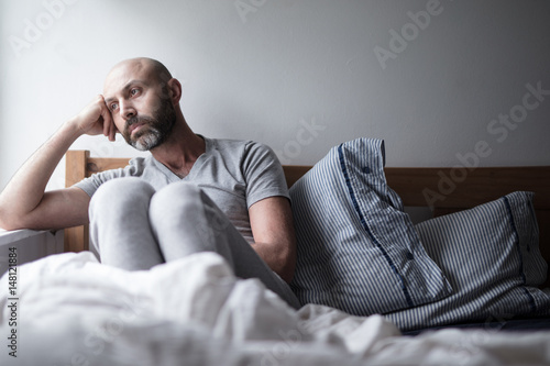 Mid forties depressed man in bed at home