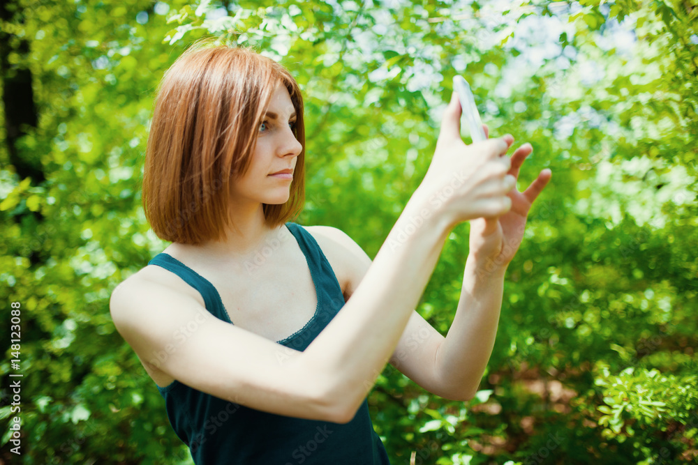 beautiful young woman make selfie with smartphone on spring flowers background beautiful young woman make selfie with smartphone on spring flowers background