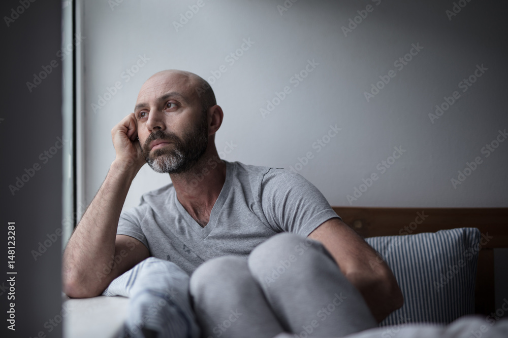 Mid forties depressed man in bed at home Mid forties depressed man in bed at home